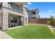 Backyard featuring an artificial turf lawn, covered patio, outdoor dining area, and privacy wall at 55 Strada Fontana, Henderson, NV 89011