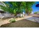 The backyard is landscaped with rock, trees, and a small patio at 5622 Sage Pines Dr, Las Vegas, NV 89118