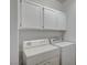 Functional laundry room with washer, dryer, and overhead white cabinets at 5622 Sage Pines Dr, Las Vegas, NV 89118