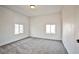 Bright bedroom featuring neutral carpet, white walls, and natural light from two windows at 603 W Adams Ave, Las Vegas, NV 89106