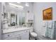 Bright bathroom featuring a white vanity with marble countertop, ample storage, and a complementary decorative wall cabinet at 6060 N Conquistador St, Las Vegas, NV 89149