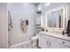 Well-appointed bathroom featuring modern vanity, decorative mirror, ample lighting, and stylish accents at 6060 N Conquistador St, Las Vegas, NV 89149