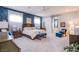 Spacious bedroom with a blue accent wall, plush carpet, and stylish furnishings at 6060 N Conquistador St, Las Vegas, NV 89149