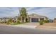 Beautiful single-story home with a three-car garage, manicured landscaping, and brick-paved driveway at 6060 N Conquistador St, Las Vegas, NV 89149