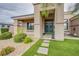 Home entrance with a beautiful green door, manicured landscaping, and walkway at 6060 N Conquistador St, Las Vegas, NV 89149