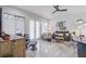 Bright living room features stylish furnishings, a ceiling fan, and access to the backyard patio through french doors at 6060 N Conquistador St, Las Vegas, NV 89149