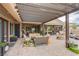 Inviting covered patio featuring ample seating, fire pit, and pergola with a view of a well-maintained backyard at 6060 N Conquistador St, Las Vegas, NV 89149