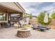 Relaxing outdoor patio with a fire pit, lounge chairs, and hanging swing, perfect for entertaining or enjoying peaceful moments at 6060 N Conquistador St, Las Vegas, NV 89149