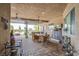 Spacious covered patio with brick flooring, ceiling fans, comfortable seating and dining, with a view of the pool at 6060 N Conquistador St, Las Vegas, NV 89149