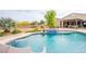 Beautiful backyard with a freeform pool, attached spa, and slide, perfect for relaxation and entertaining by the pool at 6060 N Conquistador St, Las Vegas, NV 89149