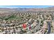 Aerial view of a residential neighborhood with houses, roads, landscaping, and mountain views at 628 Chervil Valley Dr, Las Vegas, NV 89138