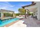 Backyard paradise boasts a tranquil pool, elegant waterfalls, and inviting covered patio at 628 Chervil Valley Dr, Las Vegas, NV 89138