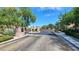 Community entrance gate with brick pillars, wrought iron gate, and mature trees on a paved road at 628 Chervil Valley Dr, Las Vegas, NV 89138