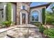 Home entrance with a stone facade, arched doorway, and well-manicured landscaping at 628 Chervil Valley Dr, Las Vegas, NV 89138