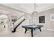 Spacious game room featuring a pool table, elegant chandelier, and staircase at 628 Chervil Valley Dr, Las Vegas, NV 89138