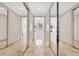 Hallway features mirrored closet doors, light stone flooring and a view of the bathroom with a large soaking tub at 628 Chervil Valley Dr, Las Vegas, NV 89138