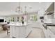 Open concept kitchen featuring a marble island, pendant lighting, and a view into the dining and living area at 628 Chervil Valley Dr, Las Vegas, NV 89138