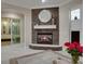 Cozy living room featuring a stone fireplace with a modern round mirror and sliding glass doors to an outdoor patio at 628 Chervil Valley Dr, Las Vegas, NV 89138