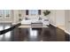 Open-concept living room with hardwood floors, a white sectional couch, and ample natural light at 628 Chervil Valley Dr, Las Vegas, NV 89138