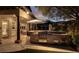 An outdoor kitchen boasts a stone surround, stainless grill, and bar seating in a relaxing backyard setting at 628 Chervil Valley Dr, Las Vegas, NV 89138