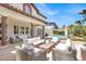 Backyard features comfortable patio seating surrounding a modern fire pit, with views of the pool and lush landscaping at 628 Chervil Valley Dr, Las Vegas, NV 89138