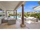 Outdoor patio features comfortable seating, stone columns, and views of the sparkling pool with water feature at 628 Chervil Valley Dr, Las Vegas, NV 89138
