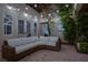 Inviting patio with stone floors, string lights, and wicker sectional seating for outdoor relaxation and entertaining at 628 Chervil Valley Dr, Las Vegas, NV 89138