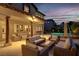 Cozy outdoor patio with comfortable seating, a fire pit, and a view of the pool at twilight at 628 Chervil Valley Dr, Las Vegas, NV 89138