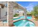 A luxurious pool featuring a rock waterfall, separate jacuzzi, and elegant tile accents at 628 Chervil Valley Dr, Las Vegas, NV 89138