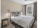 Serene bedroom featuring modern lighting, soft gray tones, large windows, and cozy furnishings at 6729 Churnet Valley Ave, Las Vegas, NV 89139