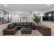 Comfortable living room with a large leather sectional sofa, ceiling fan, and stylish wall decor at 6729 Churnet Valley Ave, Las Vegas, NV 89139