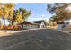 Wide shot of the home with a large driveway and charming outbuilding at 6920 Bradley Rd, Las Vegas, NV 89131