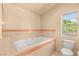 The bathroom features a large soaking tub with jets and a window for natural light at 7110 La Cienega St, Las Vegas, NV 89119