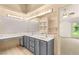 Bathroom with dual sinks, vanity, and a large mirror with modern lighting at 7110 La Cienega St, Las Vegas, NV 89119