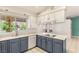 Well-lit kitchen featuring blue lower cabinets, white countertops, tile backsplash, and stainless steel appliances at 7110 La Cienega St, Las Vegas, NV 89119