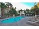 Inviting swimming pool with sun loungers, surrounded by tropical palm trees and lush greenery at 7159 S Durango Dr # 206, Las Vegas, NV 89113