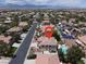 Gorgeous aerial view of a home, neighboring properties, a community pool, and the mountains in the distance at 7310 Heggie Ave, Las Vegas, NV 89131
