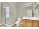 Bright bathroom with tiled floor, glass-enclosed shower, white toilet, and sink with wooden cabinetry at 7310 Heggie Ave, Las Vegas, NV 89131