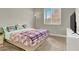 Bedroom with neutral carpet, a TV and a large bright window at 7310 Heggie Ave, Las Vegas, NV 89131