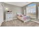 Bedroom with a large window, dresser and light-colored carpet and walls at 7310 Heggie Ave, Las Vegas, NV 89131