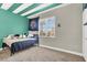 Bright bedroom featuring a bed, window with blinds, and a green accent wall at 7310 Heggie Ave, Las Vegas, NV 89131