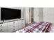 Cozy bedroom featuring a plaid comforter and a white dresser with a modern television at 7310 Heggie Ave, Las Vegas, NV 89131