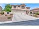 Charming two-story home with a balcony, tile roof and driveway leading to the two-car garage at 7310 Heggie Ave, Las Vegas, NV 89131