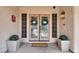 Elegant double front doors adorned with wreaths, flanked by decorative planters and sconce lighting at 7310 Heggie Ave, Las Vegas, NV 89131