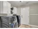 Functional laundry room with modern washer and dryer, white cabinets and tiled floors at 7310 Heggie Ave, Las Vegas, NV 89131