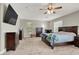 Main bedroom featuring a dark wood bed frame, ceiling fan, television, and lots of dresser space at 7310 Heggie Ave, Las Vegas, NV 89131