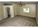 Spacious bedroom with neutral carpet, ceiling fan, and an open doorway to a hallway at 7429 Fencerow St, Las Vegas, NV 89131