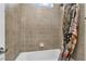 Neutral tile surrounds the tub-shower combination in this cozy bathroom at 7778 Villa Montara St, Las Vegas, NV 89123