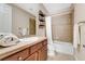 Neutral bathroom featuring tile flooring, wooden vanity, and shower-tub combo at 7778 Villa Montara St, Las Vegas, NV 89123
