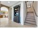 Hallway with tile floors, elegant staircase, and a decorative cabinet at 7778 Villa Montara St, Las Vegas, NV 89123